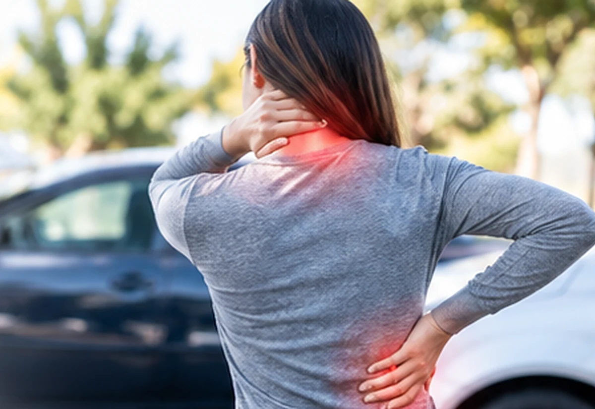 Person holding neck and lower back after a vehicle collision